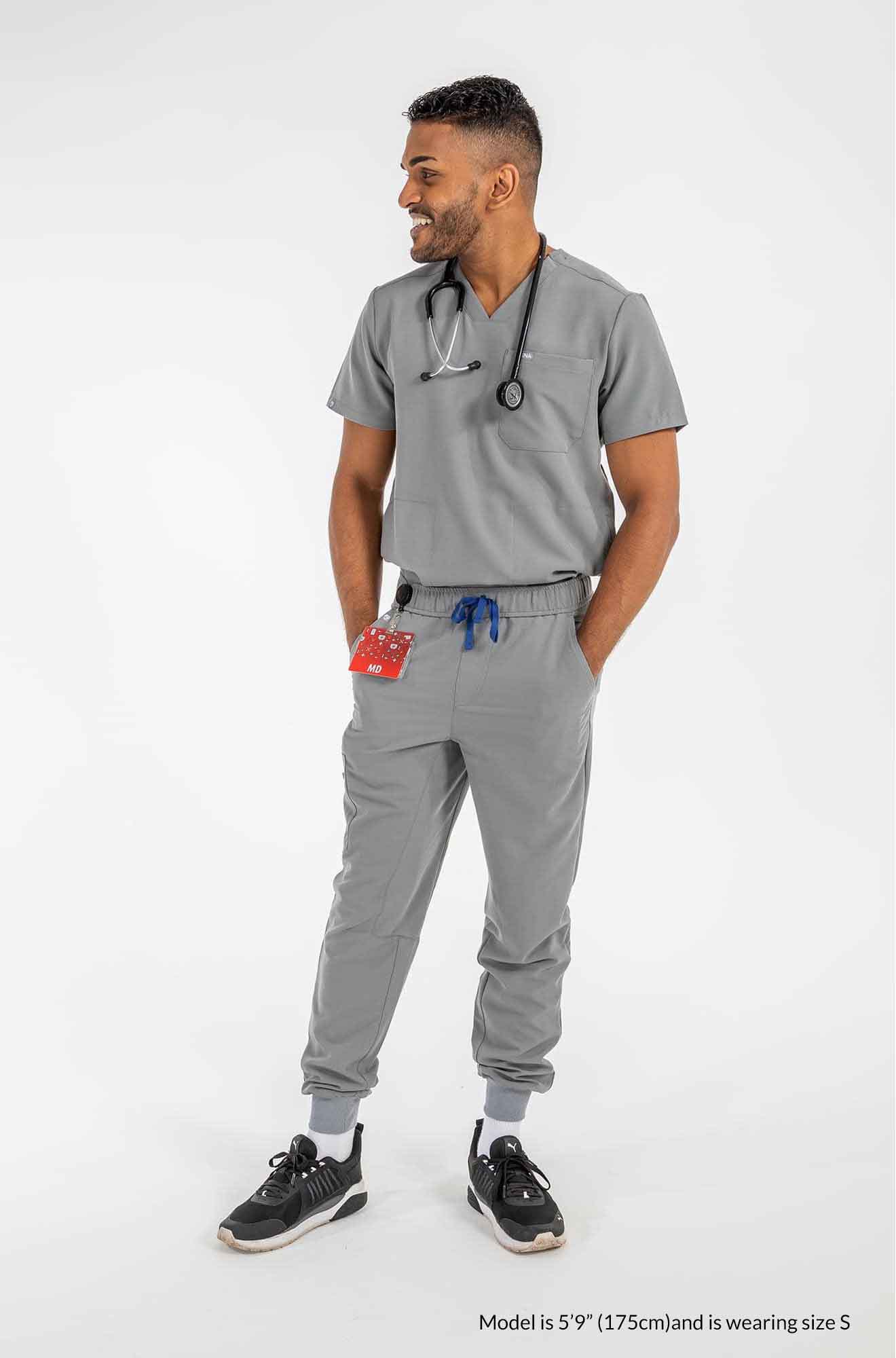 Men's DEX Jogger Scrub Pants, Gentleman holding 2 front pockets of scrub pants #colour_grey