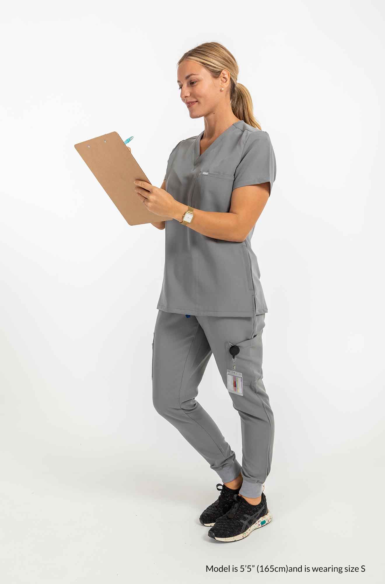 Women's SAYA Jogger Scrub Pant, Lady wearing complete set of scrub, shes also holding a checklist #colour_grey