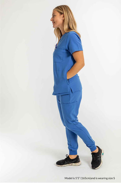 Women's SAYA Jogger Scrub Pant, Lady featuring full set  of scrub both hands are inside the scrub top pockets #colour_royal-blue