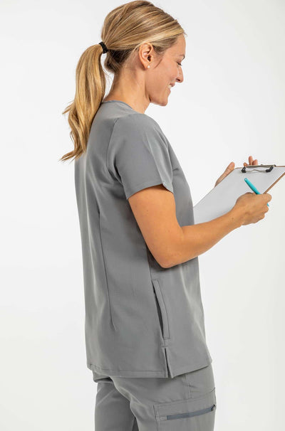 Women's ATRIUM Scrub Top, Grey Shirt, Lady holding checklist facing back#colour_grey