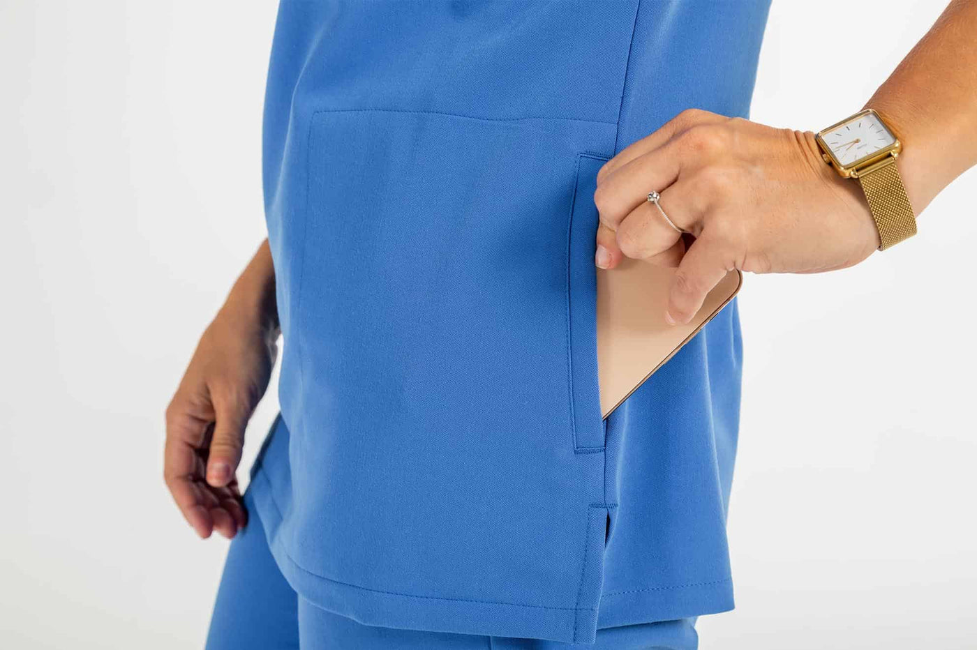 Women's ATRIUM Scrub Top, Lady putting her mobile in the side pocket of scrub shirt#colour_royal-blue