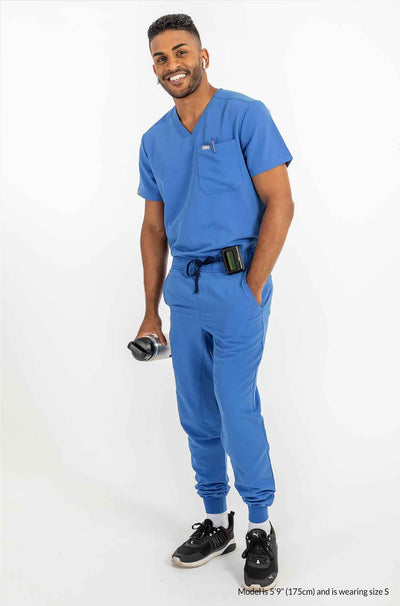 Men's AESON Scrub Top, Men holding water bottle on right hand and the left hand is inside the pocket #colour_royal-blue